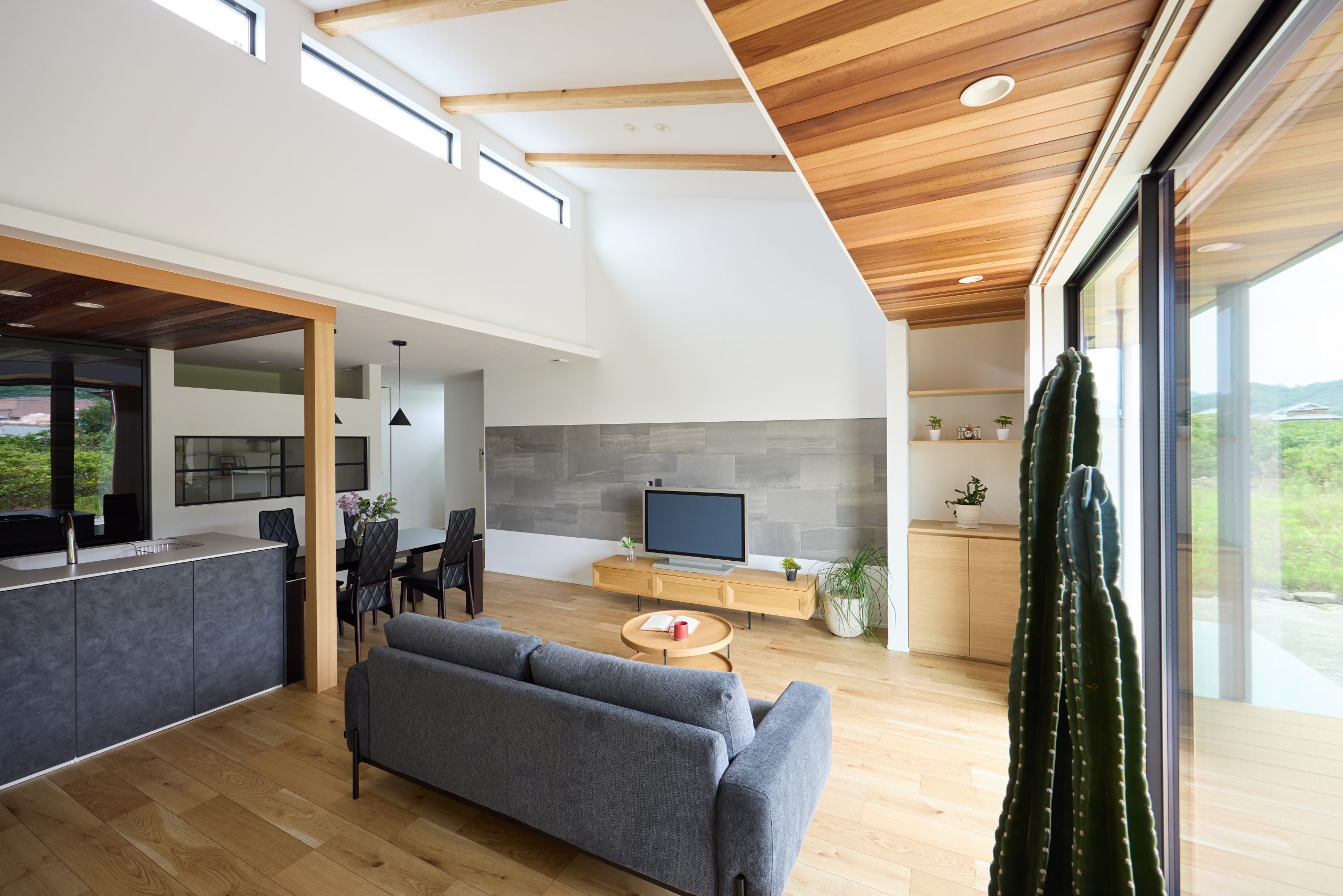 木目の温もりとグレータイルが調和する、開放的な勾配天井のLDK